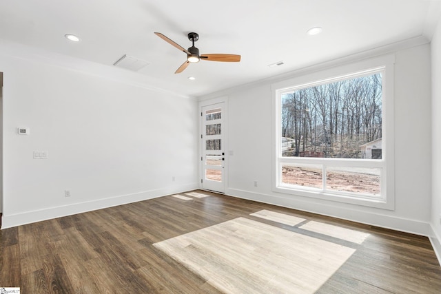 spare room featuring baseboards, dark wood finished floors, crown molding, and recessed lighting