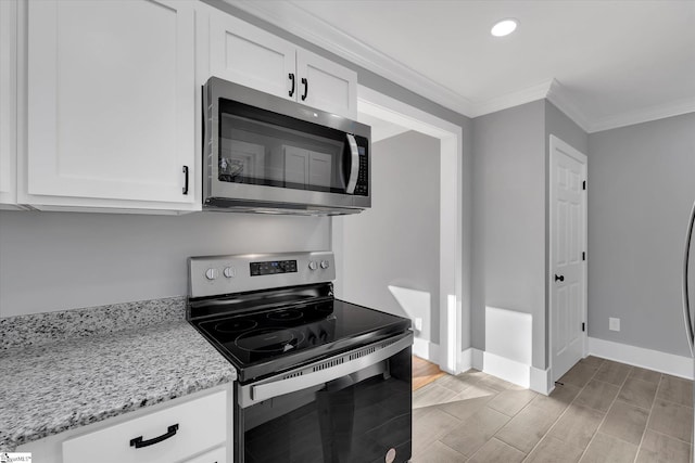 kitchen with light stone counters, stainless steel appliances, white cabinetry, baseboards, and ornamental molding