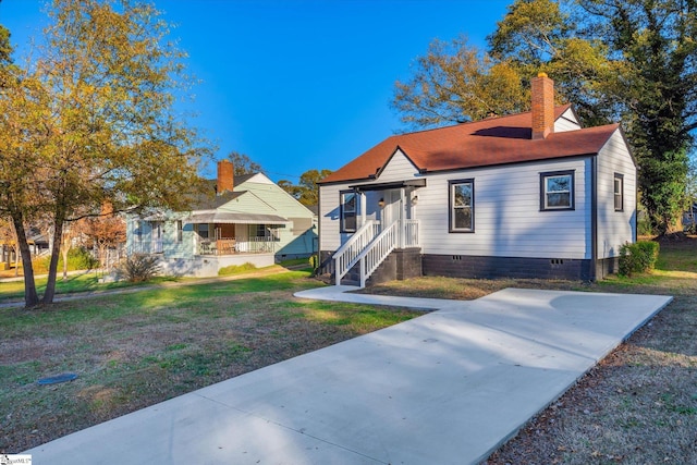 bungalow with crawl space, a chimney, and a front yard