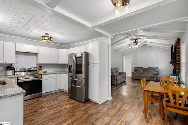 kitchen with light stone counters, dark wood-style flooring, white cabinetry, open floor plan, and appliances with stainless steel finishes