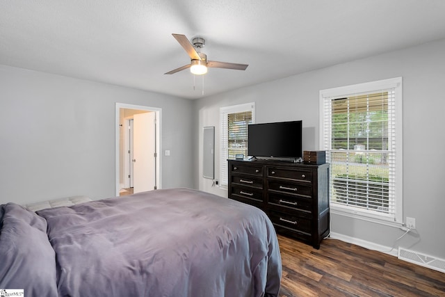 bedroom featuring baseboards, visible vents, dark wood finished floors, and a ceiling fan