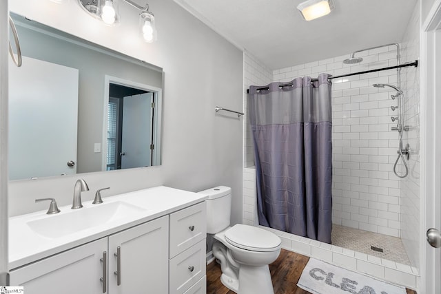 bathroom with vanity, a stall shower, wood finished floors, and toilet