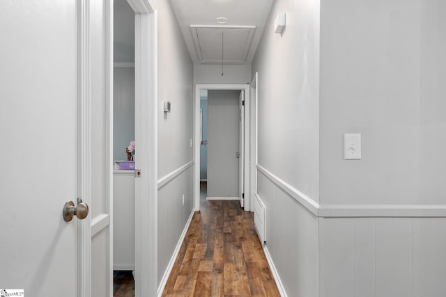 hall featuring dark wood-style floors, attic access, and wainscoting