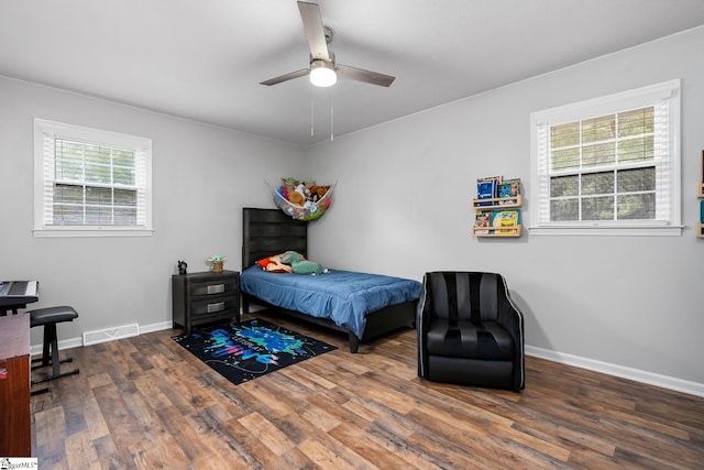 bedroom with visible vents, multiple windows, baseboards, and dark wood-style flooring