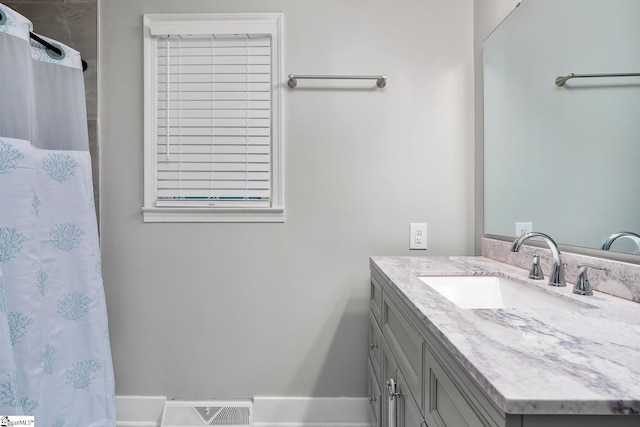 bathroom with curtained shower, vanity, and visible vents