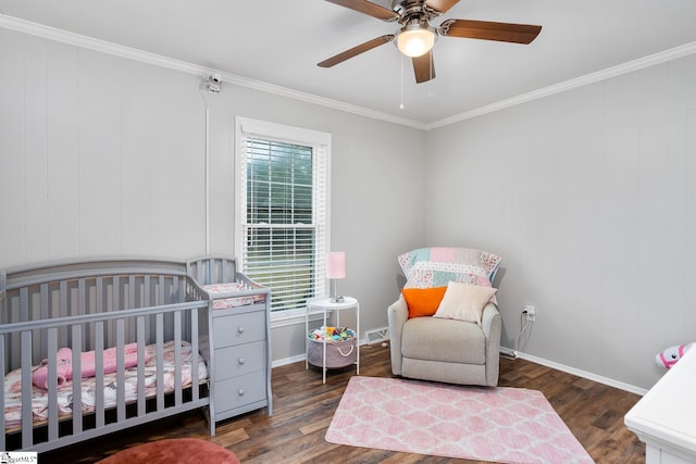 bedroom featuring a crib, visible vents, dark wood-style floors, ceiling fan, and ornamental molding