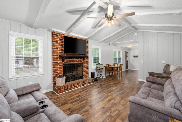 living room featuring dark wood-style flooring, a fireplace, plenty of natural light, and lofted ceiling with beams