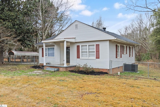 bungalow-style home with a front yard, central AC, fence, and a detached carport