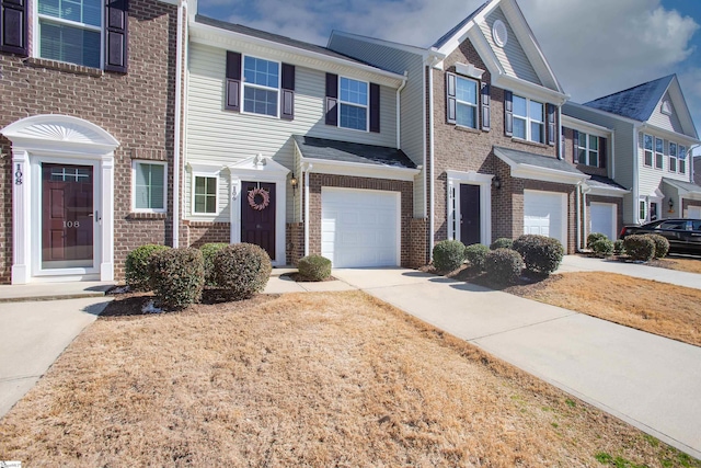 view of property featuring a garage, driveway, and brick siding