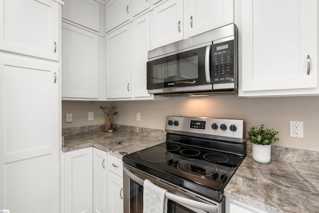 kitchen featuring appliances with stainless steel finishes, light stone counters, and white cabinets