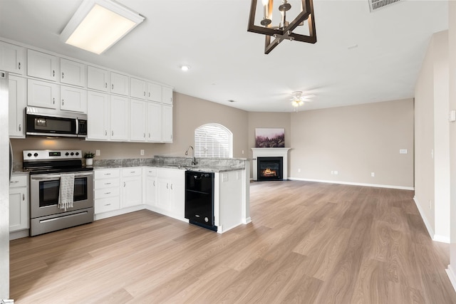 kitchen with white cabinetry, stainless steel appliances, a sink, and open floor plan