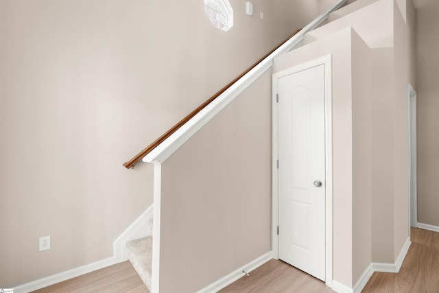 staircase featuring baseboards and wood finished floors