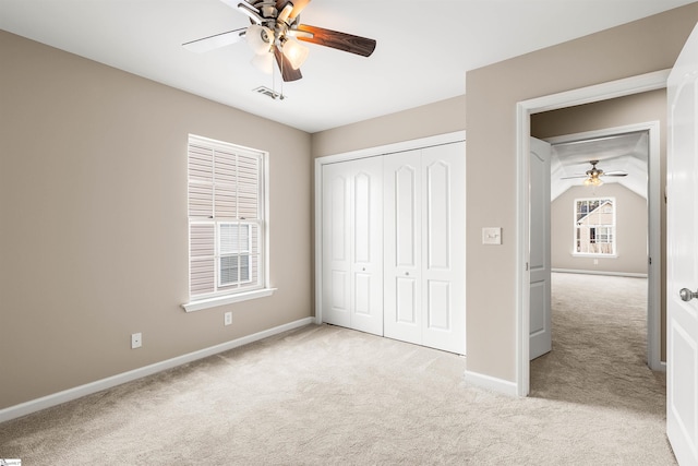 unfurnished bedroom with light carpet, a ceiling fan, visible vents, baseboards, and a closet