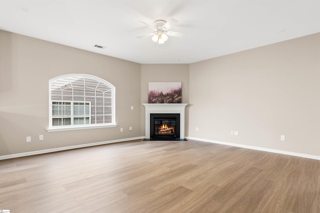 unfurnished living room featuring light wood finished floors, baseboards, and visible vents