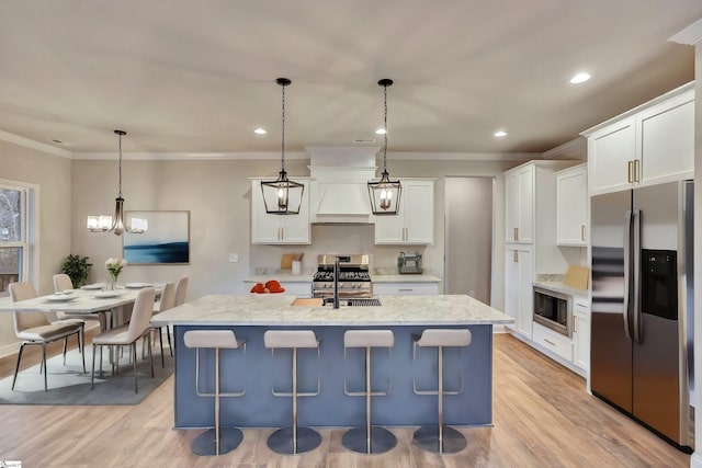 kitchen with stainless steel appliances, an island with sink, white cabinets, and pendant lighting