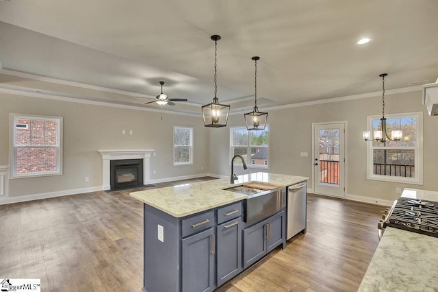 kitchen featuring decorative light fixtures, open floor plan, an island with sink, light stone countertops, and dishwasher