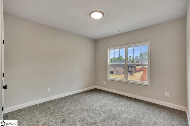 carpeted empty room featuring visible vents and baseboards