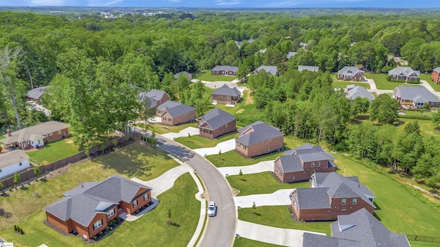 drone / aerial view with a wooded view and a residential view