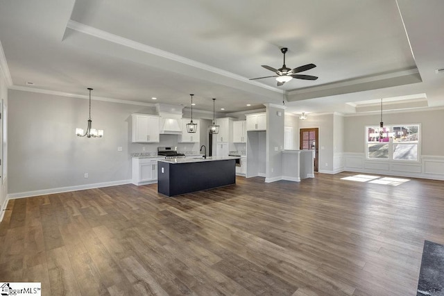 kitchen with stainless steel range, white cabinets, open floor plan, light countertops, and pendant lighting