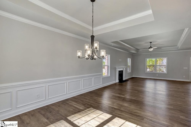 unfurnished living room with dark wood-style floors, a fireplace, a raised ceiling, and crown molding