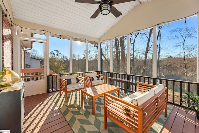 sunroom / solarium with lofted ceiling, wood ceiling, and a ceiling fan