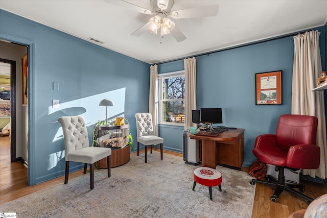 sitting room featuring visible vents, ceiling fan, baseboards, and wood finished floors