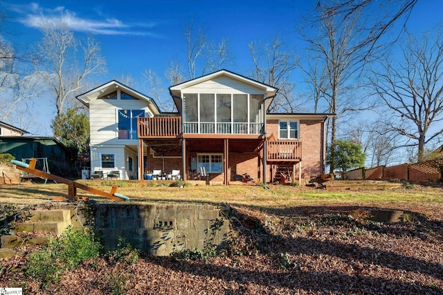 back of property with stairs, a deck, and a sunroom