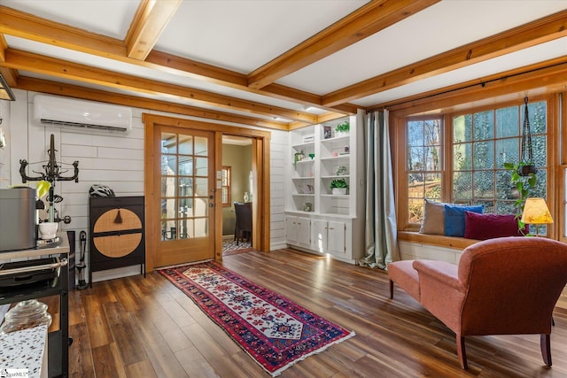 living area with a wall unit AC, dark wood finished floors, beam ceiling, and french doors