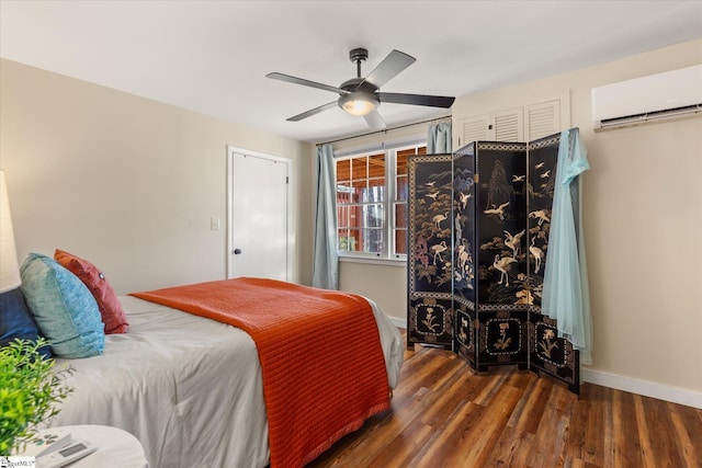 bedroom featuring a ceiling fan, an AC wall unit, dark wood finished floors, and baseboards