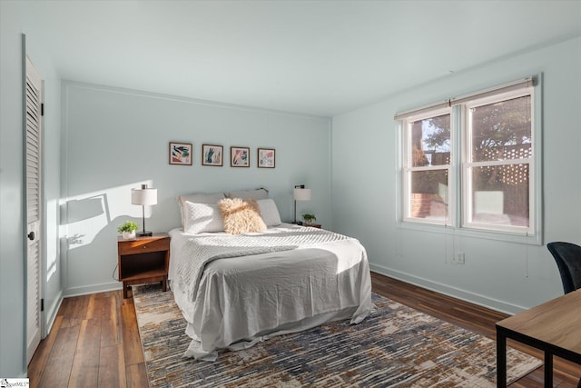 bedroom with baseboards and dark wood-style flooring