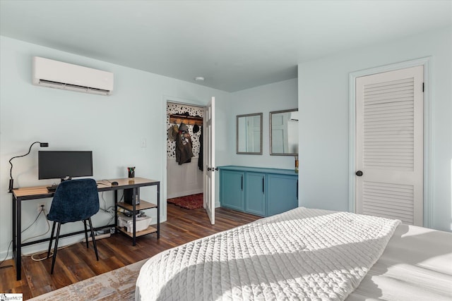 bedroom with dark wood-style floors, a closet, a spacious closet, an AC wall unit, and baseboards