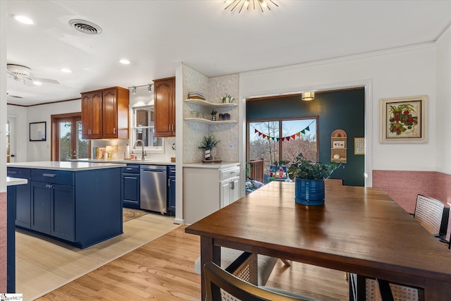 kitchen with visible vents, a center island, light countertops, open shelves, and stainless steel dishwasher