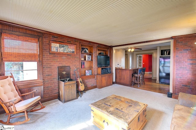 living room featuring light carpet and brick wall