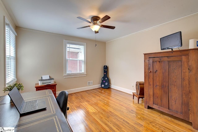 office space featuring light wood-style floors, visible vents, ornamental molding, and baseboards