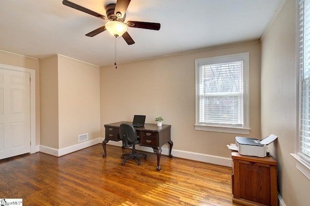 office space featuring crown molding, visible vents, ceiling fan, wood finished floors, and baseboards