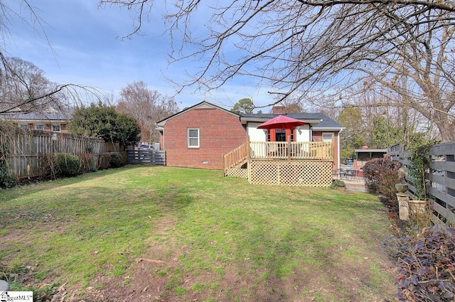 exterior space with crawl space, a fenced backyard, a wooden deck, and brick siding