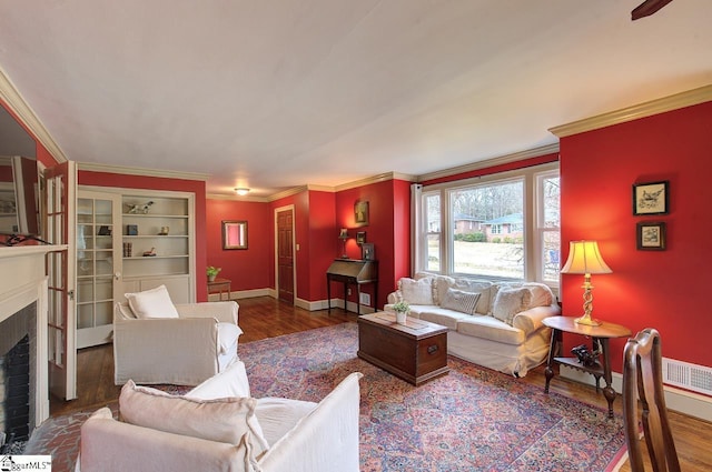 living area with dark wood-style floors, baseboards, a fireplace, and ornamental molding