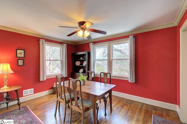 dining area featuring ornamental molding, visible vents, baseboards, and wood finished floors