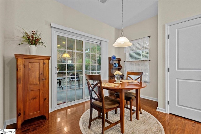 dining space with dark wood-style floors, a healthy amount of sunlight, and baseboards