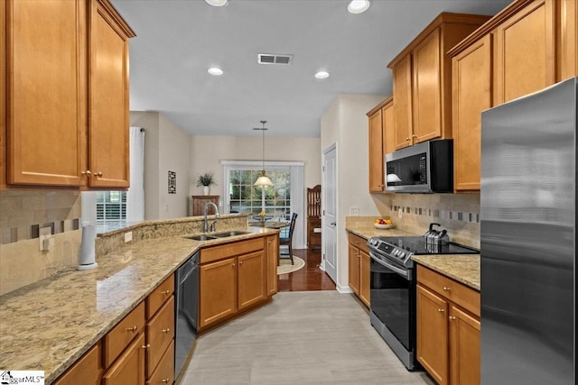 kitchen with stainless steel appliances, brown cabinetry, and a sink