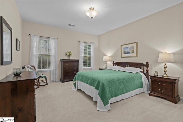 bedroom with light carpet, visible vents, and baseboards