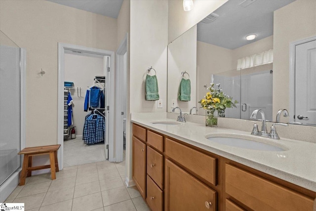 full bathroom featuring a shower stall, a walk in closet, and a sink