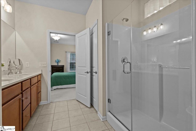 ensuite bathroom featuring double vanity, a stall shower, tile patterned floors, ensuite bathroom, and a sink