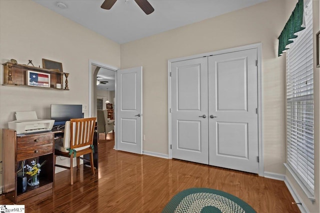 office area with a ceiling fan, baseboards, and wood finished floors