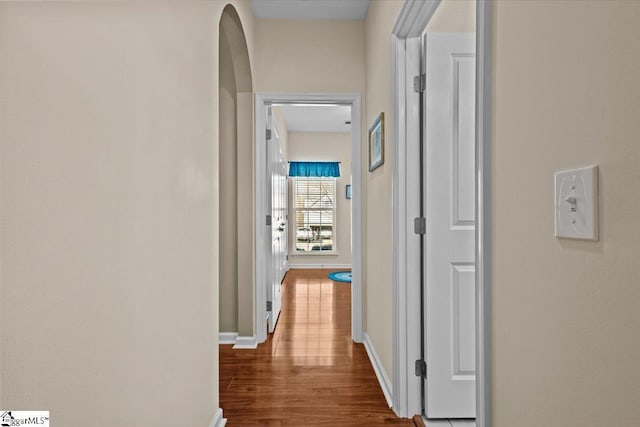 hall featuring baseboards and wood finished floors