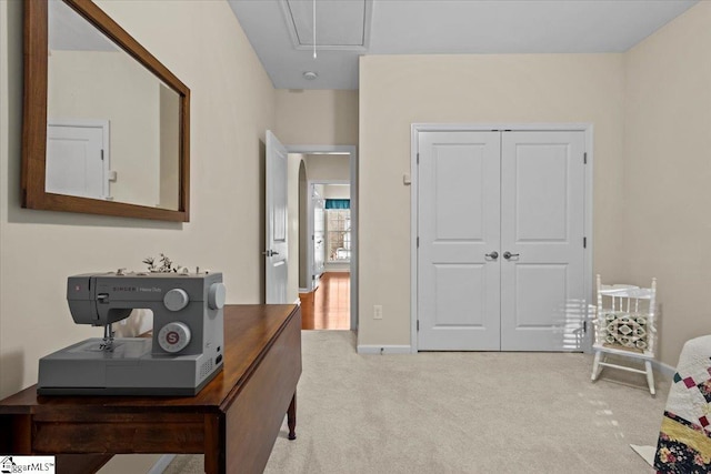 interior space with attic access, a closet, light colored carpet, and baseboards