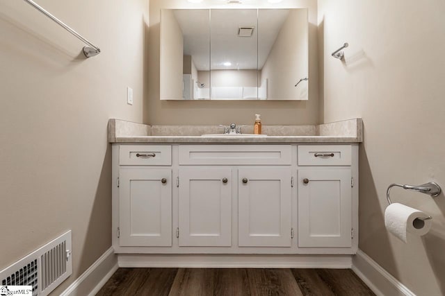 bathroom with baseboards, visible vents, wood finished floors, and vanity
