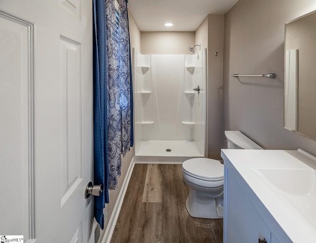 full bath featuring vanity, a shower stall, toilet, and wood finished floors