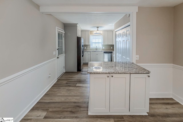 kitchen with light stone countertops, white cabinetry, dark wood-style floors, and appliances with stainless steel finishes