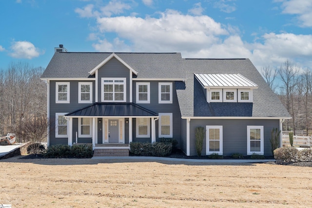 view of front facade featuring a standing seam roof, covered porch, metal roof, and roof with shingles